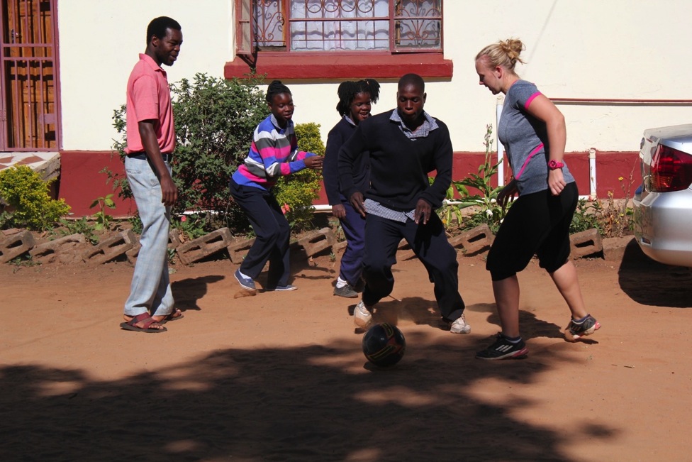 Student Andrew shows off his amazing football skills to fellow volunteer Fiona during sports 