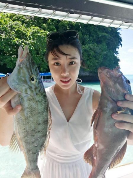 Jingying Ye holding two fish