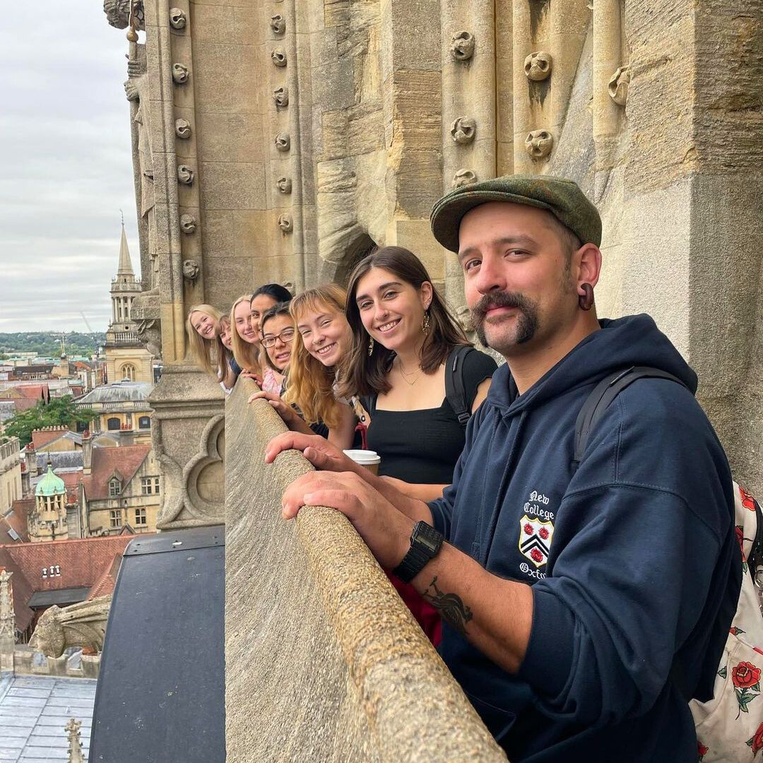 Students pose for a picture while looking out at a picturesque view of Oxford, England
