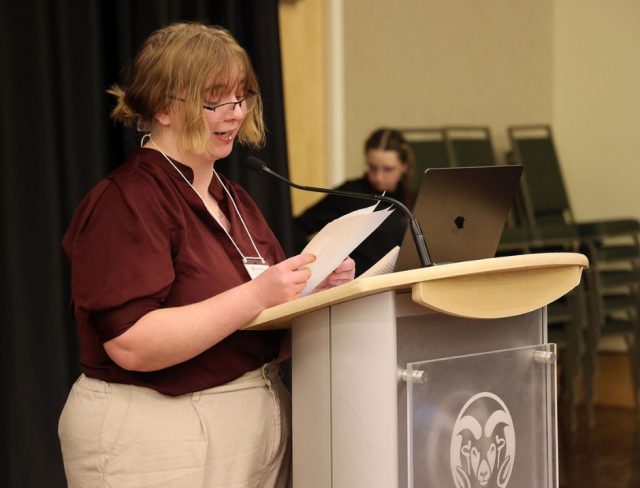 Gradshow_web2 Autumn Koors-Foltz reading from paper at podium at Graduate Student Showcase, Nov. 19.