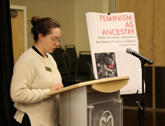 Gradshow_web4 Bianca Glinskas presenting beside poster titled "Feminism as Ancestry" at Graduate Student Showcase, Nov. 19.