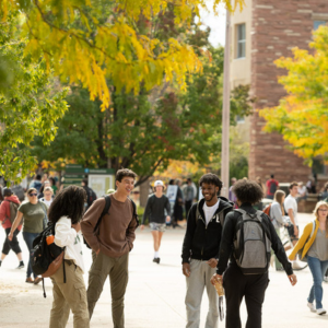Students gather outside the Clark building on a fall day.