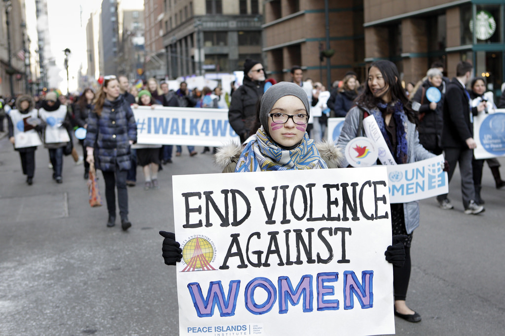 Image from International Women's Day, woman holding sign.