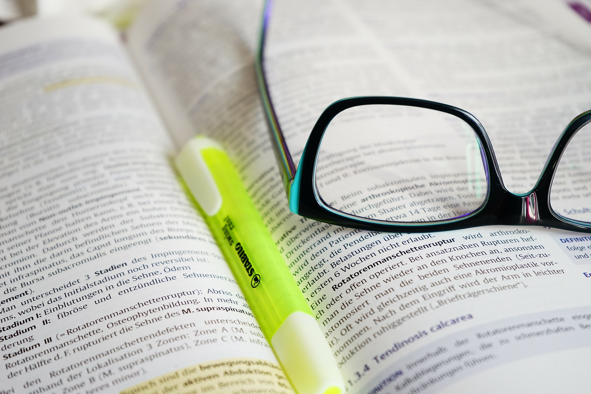 Glasses and highlighter resting on book