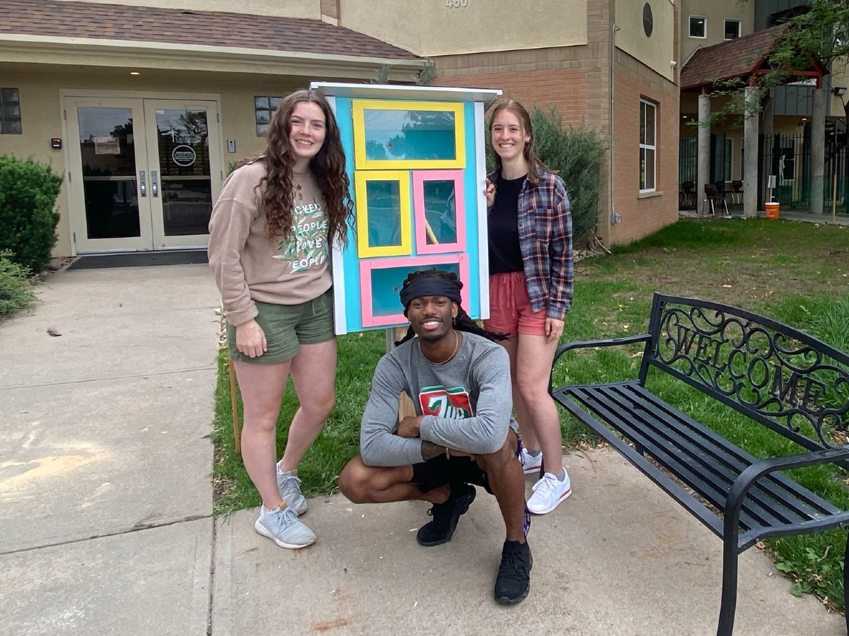 IAD Students working on the Little Library outside of the Catholic Charities building