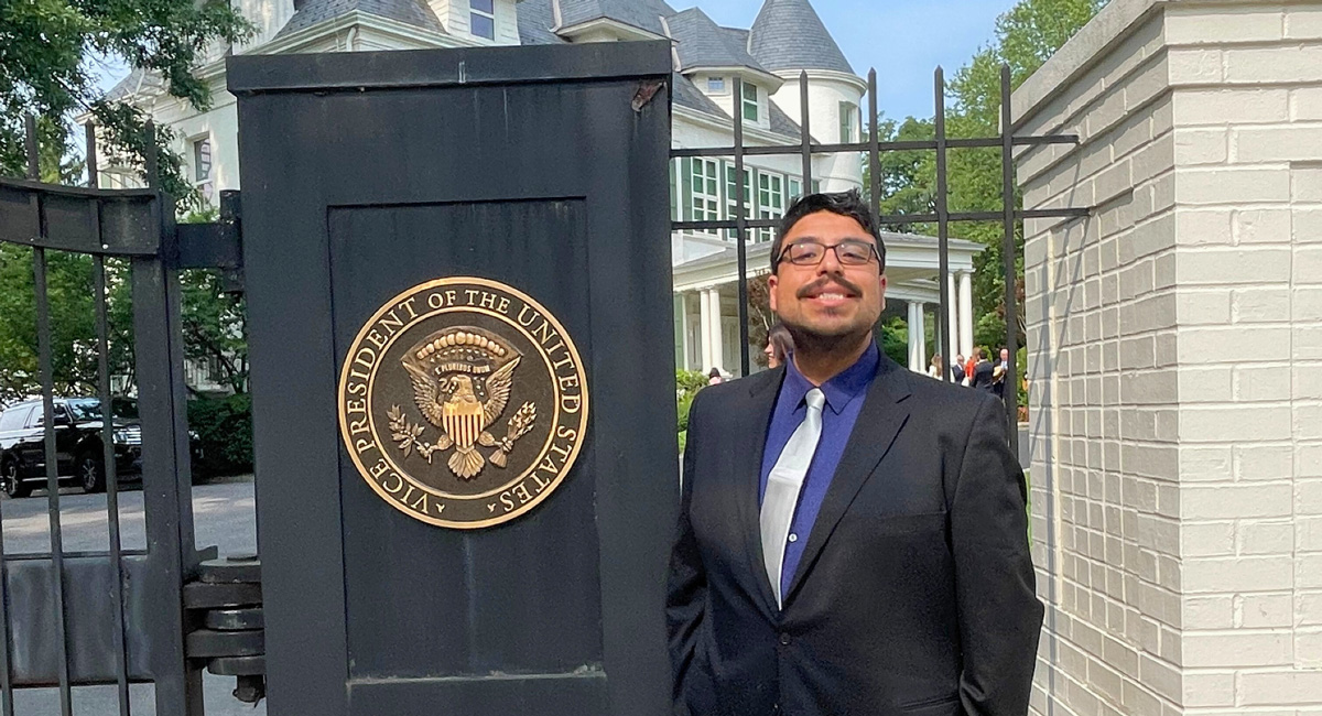 Caleb González poses at the entrance of Harris’ home