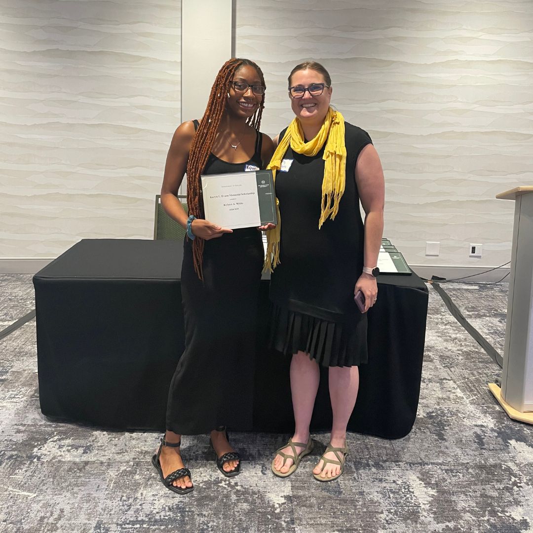 Student and instructor pose for photo together at the English department awards ceremony in April 2024.