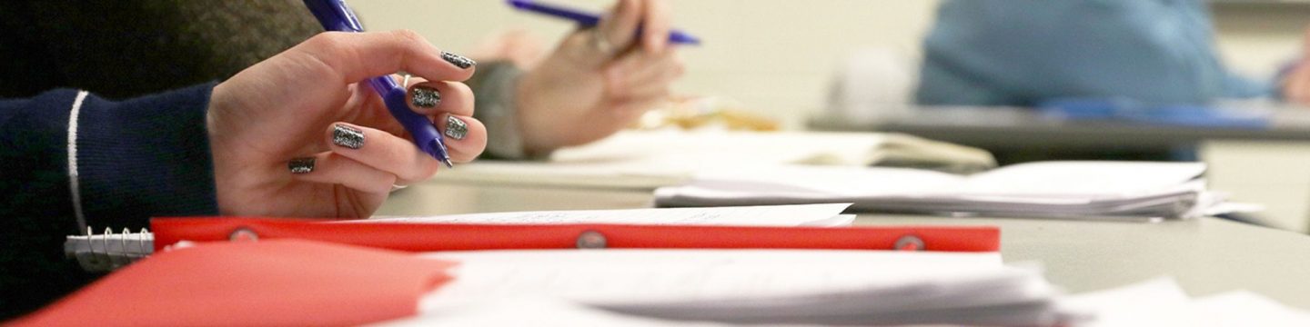 Close-up of students writing.