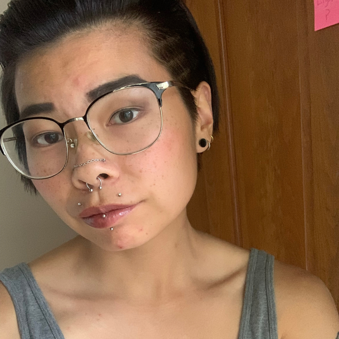 Portrait of Carli Houston. Student has short black hair and is wearing glasses and a gray tank top.