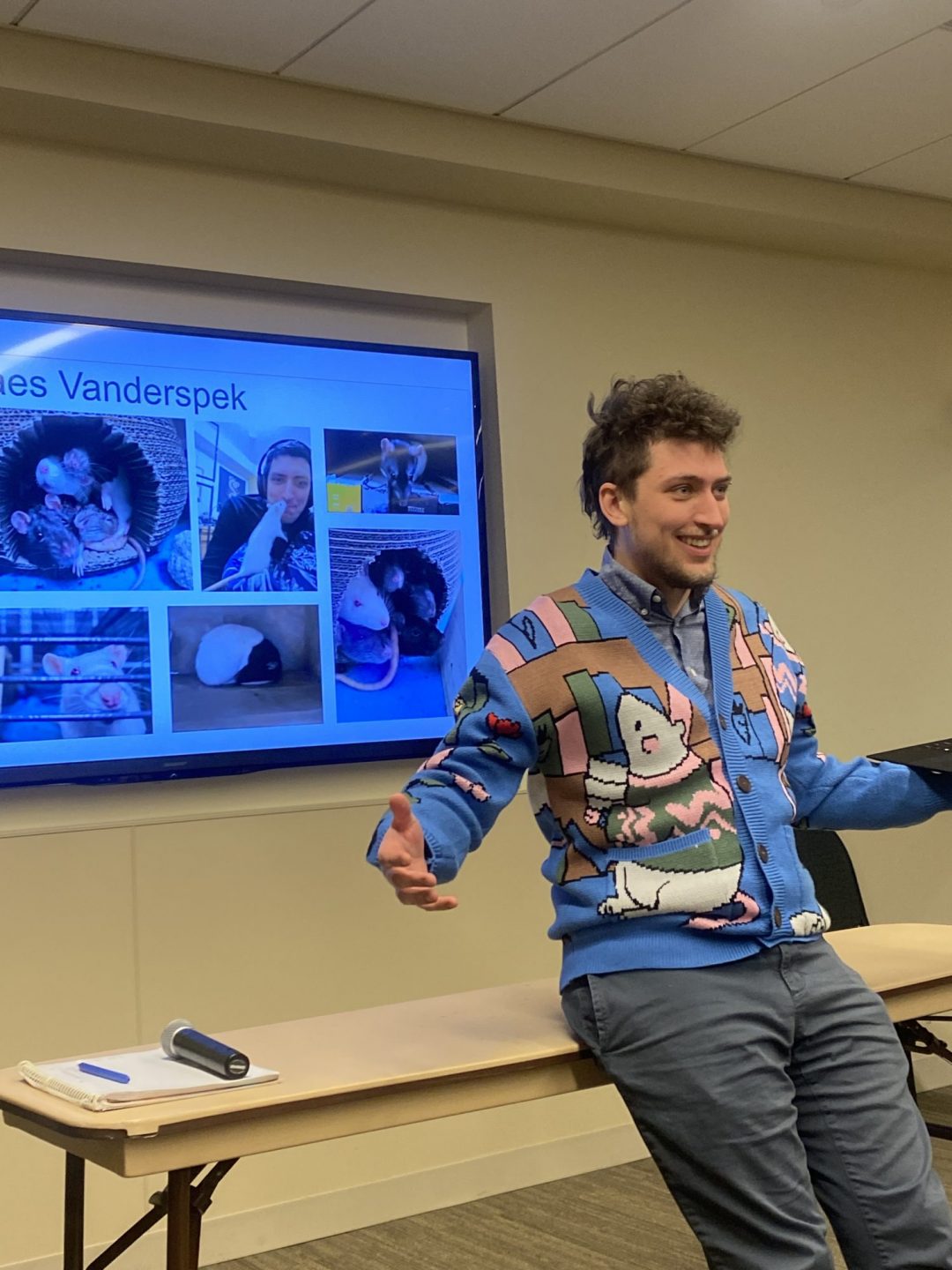 Kaes Vanderspek sits and presents at the front of a classroom during the EGSA Fall Salon.
