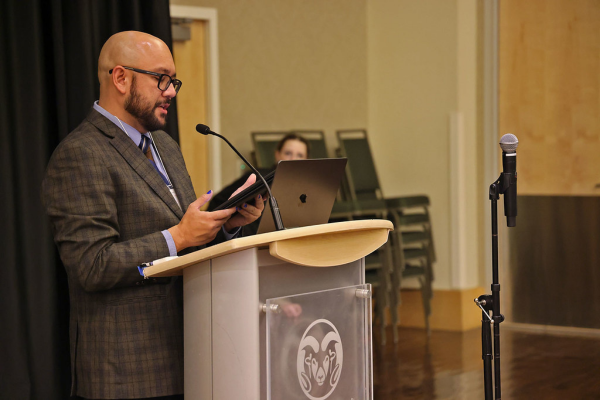 MFA student reads at a podium during the 2025 Graduate Student Showcase.