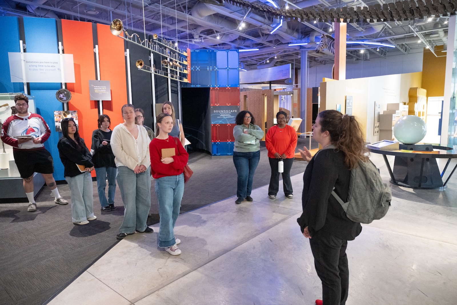 Students face and listen to an instructor talking in the Fort Collins Museum of Discovery.