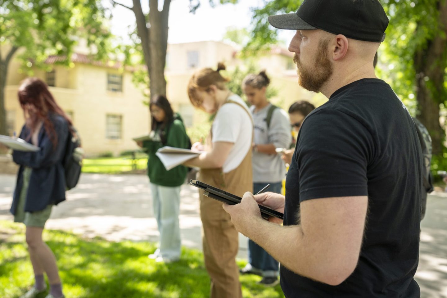 Students stand and write during an outdoor class on CSU campus.