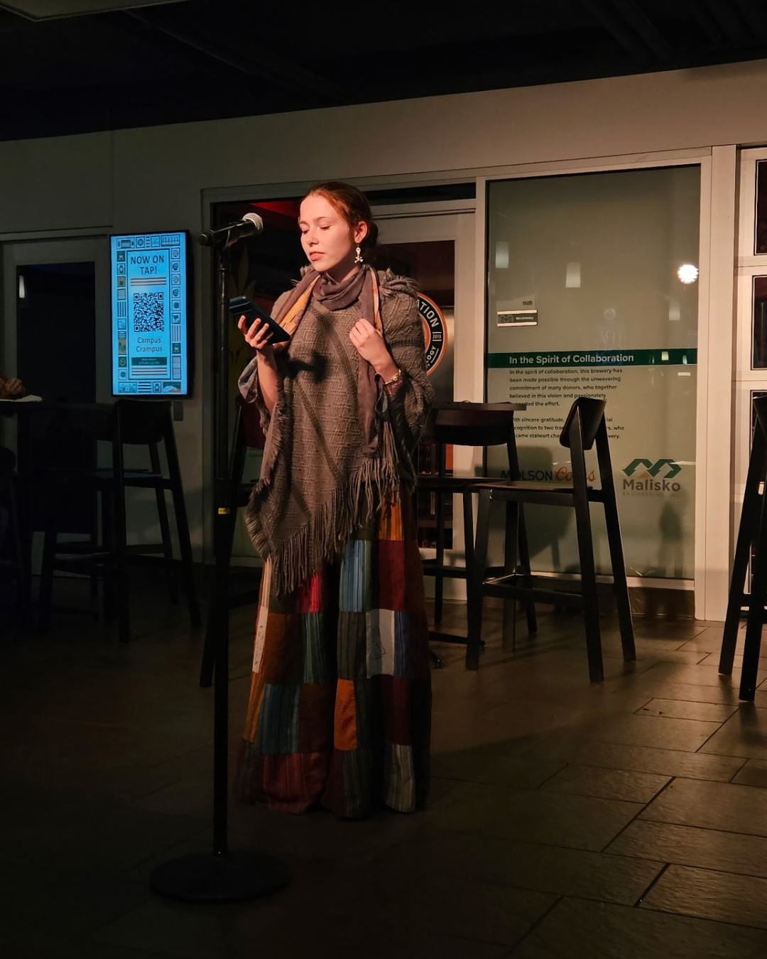 Student in Dead Poets Society reads work at open mic night.